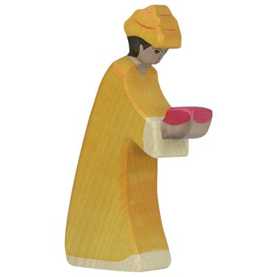 Wooden figurine of a person in yellow robes holding pink objects on a white background