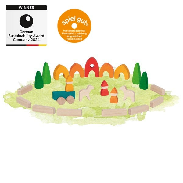 Colorful wooden toy set with animals and a train on a green base, featuring sustainability awards on a white background.
