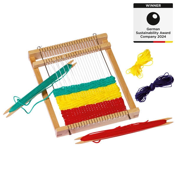 Wooden weaving loom with colorful threads and a 'Winner' label for German Sustainability Award 2024 on a white background.