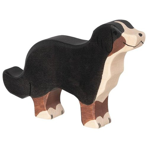 Wooden dog figurine with black, brown, and white colors on a white background